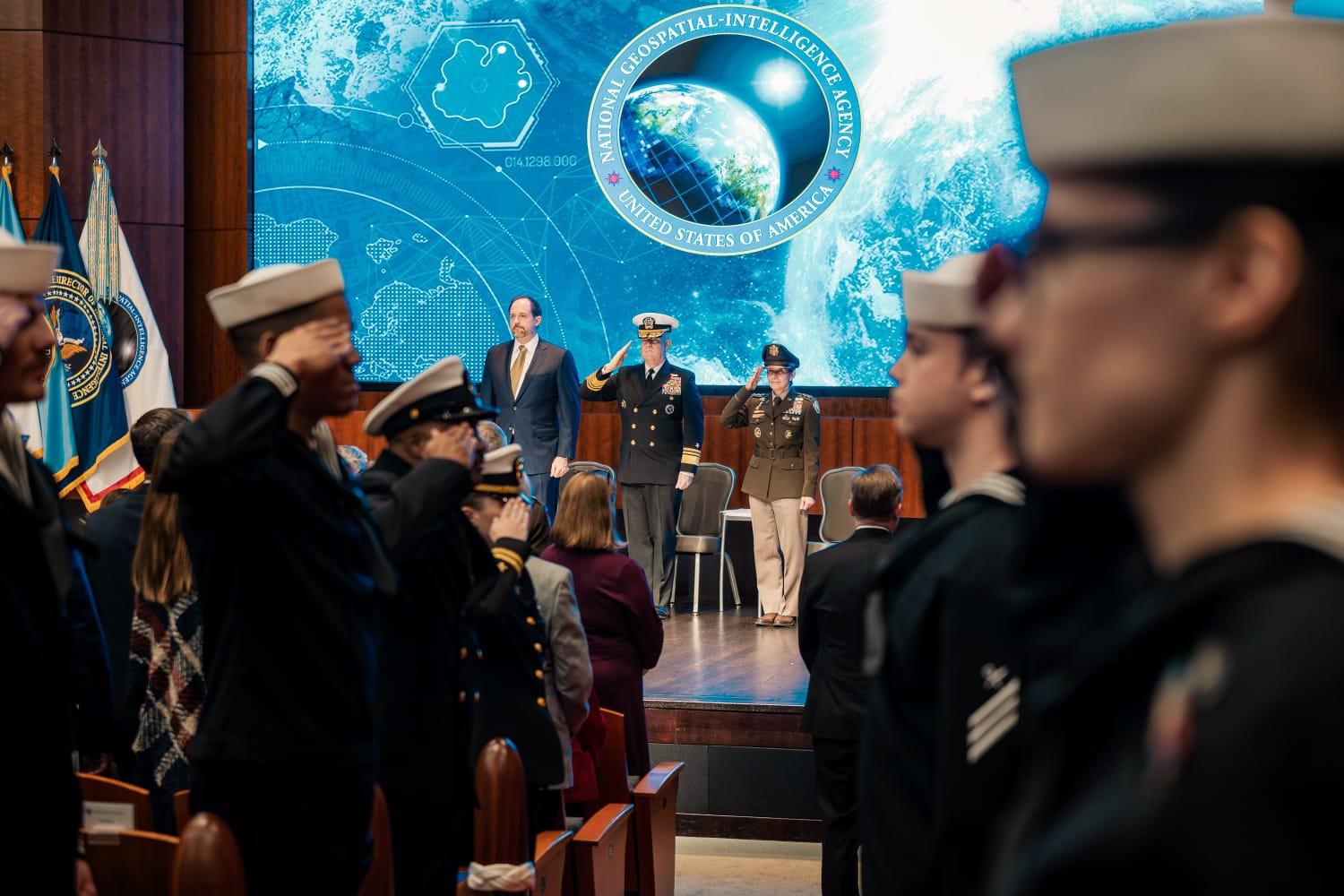 (Left to right) Under Secretary of War for Intelligence and Security Bradley Hansell, outgoing Director Navy Vice Adm. Frank D. Whitworth III and incoming Director U.S. Army Lt. Gen. Michele H. Bredenkamp stand at attention and salute during the change of directorship held at NGA Washington Nov. 5. (Photos by NGA Office of Corporate Communications)