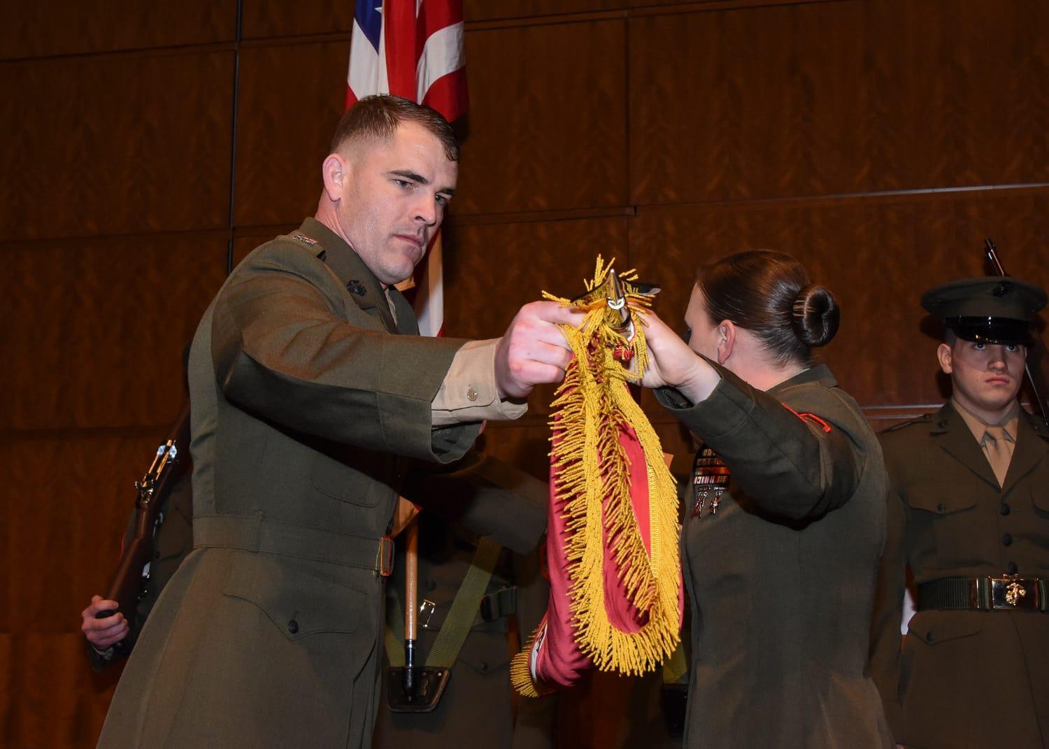 ['Marine Corps Capt. Nathan Nofziger and Gunnery Sgt. Heidi Hill case the colors during the deactivation ceremony of Marine Corps Detachment Fort Belvoir March 26 at the National Geospatial-Intelligence Agency\u2019s Springfield, Virginia, campus. Nofziger is the detachment commander and Hill is its senior enlisted adviser. Photo by Erica Knight, NGA Office of Corporate Communications.']