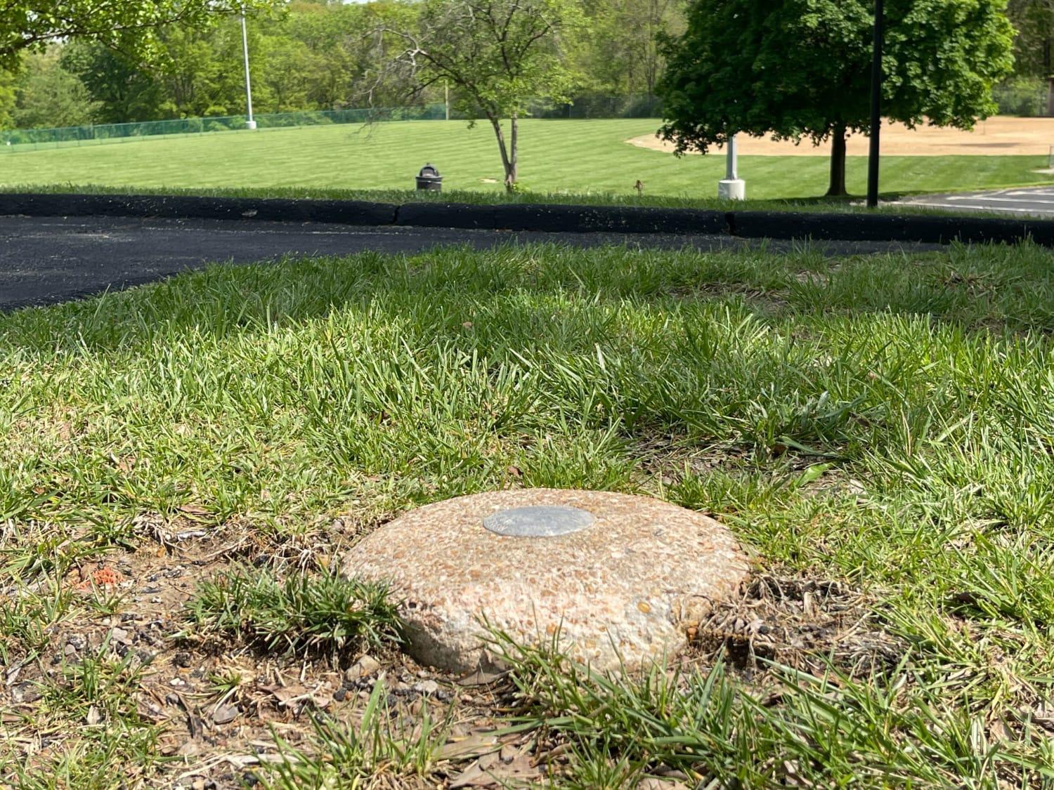 An example of a National Geodetic Survey monument, found in Whitecliff Park near St. Louis. These monuments, built into the ground throughout the United States, tell surveyors the latitude and longitude of certain points, allowing surveyors to accurately calculate their own location and distances between points.  (Photo by Karen Moehlman, Office of Corporate Communications)