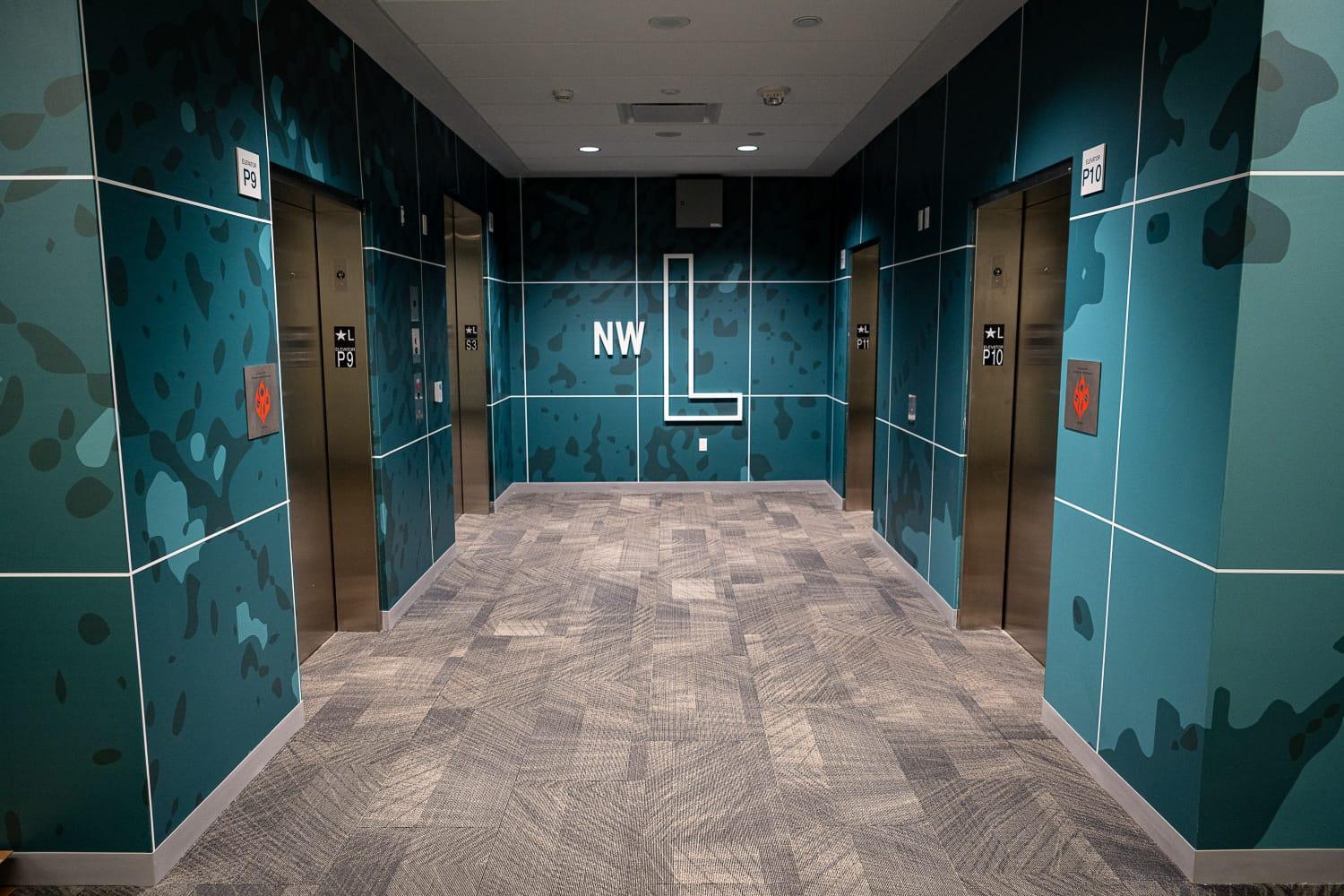 Decorative wrapping and paint schemes representing sea, land, air and space are being installed on elevator bays and walls to reflect NGA’s GEOINT mission domains and visually mark different floors of the building. Thematic colors range from deep turquoise blues on the lower “sea” level (shown here) to light grays and yellows on the upper “space” level. (Photos by NGA)